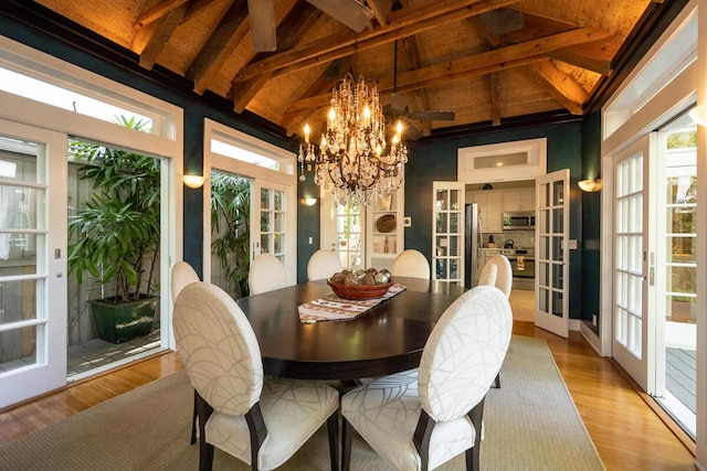 dining space with a chandelier, french doors, beamed ceiling, and light wood finished floors