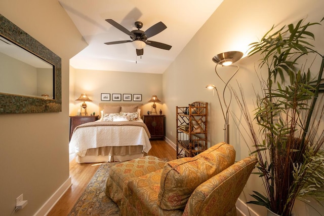 bedroom featuring lofted ceiling, ceiling fan, wood finished floors, and baseboards