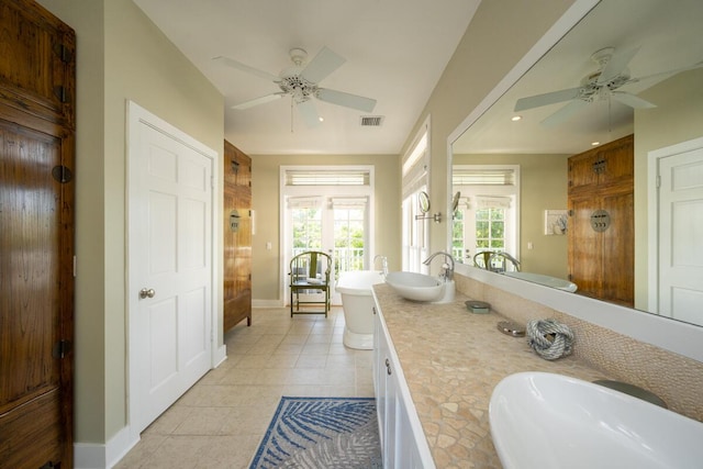 full bath featuring a soaking tub, visible vents, a sink, and tile patterned floors