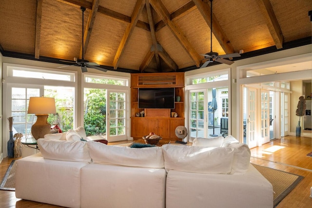 living room with beam ceiling, french doors, a ceiling fan, wood finished floors, and high vaulted ceiling