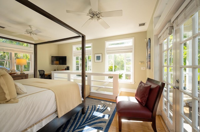 bedroom with french doors, visible vents, and wood finished floors