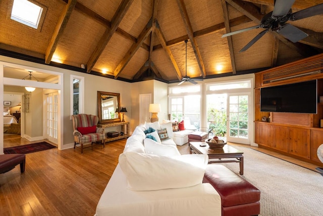 living room featuring baseboards, ceiling fan, wood finished floors, high vaulted ceiling, and beam ceiling