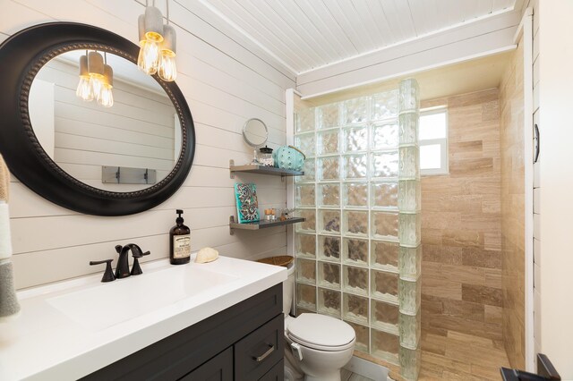 bathroom featuring vanity, toilet, and tiled shower