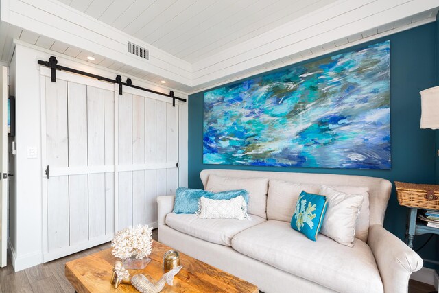 living room with crown molding, hardwood / wood-style flooring, and a barn door