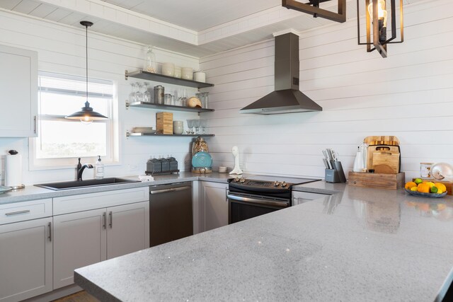 kitchen featuring pendant lighting, wall chimney range hood, dishwasher, light stone counters, and range with electric stovetop