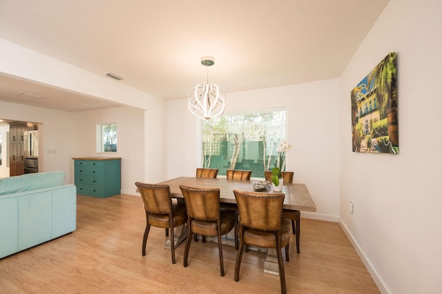 dining space with visible vents, a notable chandelier, light wood-style flooring, and baseboards