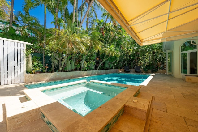 outdoor pool featuring a patio area, a fenced backyard, and an in ground hot tub