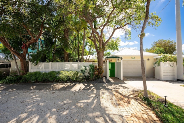 exterior space featuring a garage, a fenced front yard, and decorative driveway