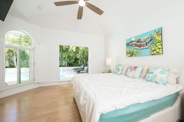 bedroom with access to exterior, lofted ceiling, a ceiling fan, and wood finished floors