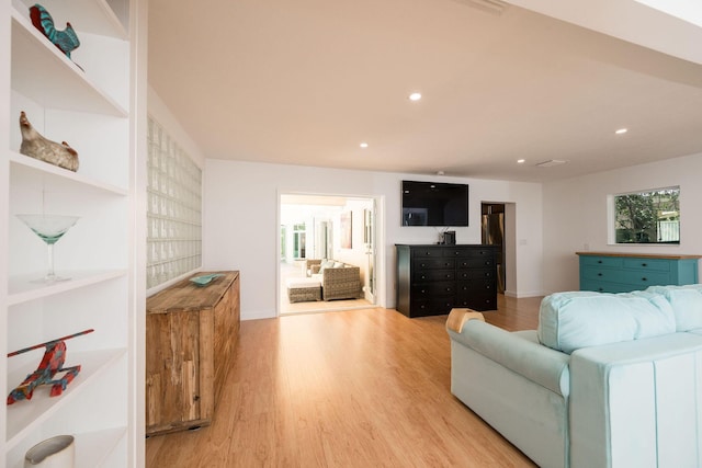 living area featuring recessed lighting, baseboards, and light wood finished floors