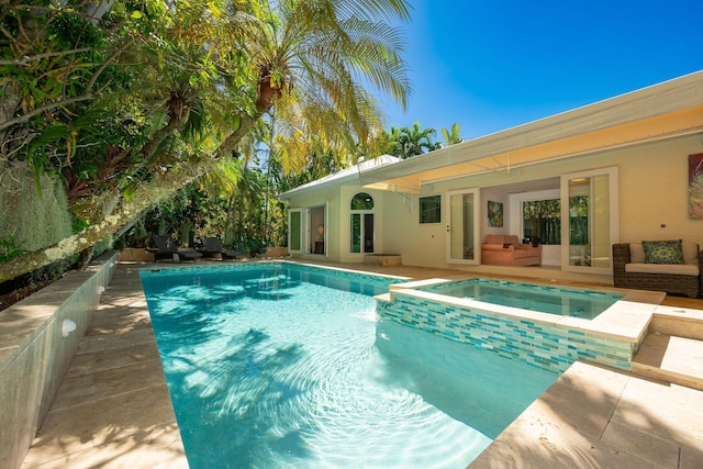 view of swimming pool with a pool with connected hot tub, a patio area, and an outdoor living space