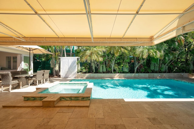 view of pool with outdoor dining area, a patio area, fence, and a pool with connected hot tub