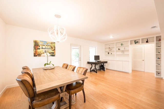 dining room featuring a chandelier, light wood-style flooring, visible vents, and baseboards