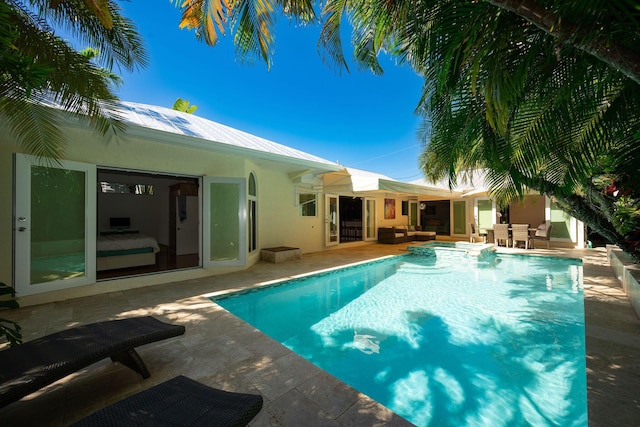 view of swimming pool featuring a pool with connected hot tub, an outdoor living space, and a patio