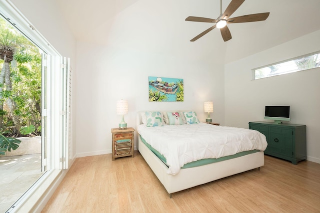 bedroom featuring access to exterior, multiple windows, and light wood-style flooring