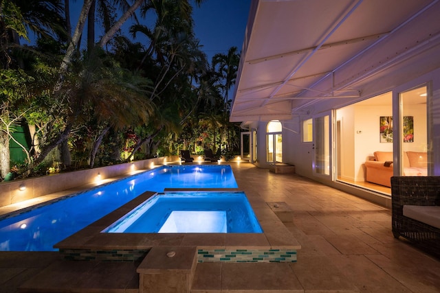 pool at twilight with an in ground hot tub, a patio, and an outdoor pool