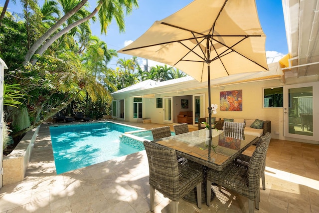 view of swimming pool featuring a pool with connected hot tub, outdoor dining area, and a patio