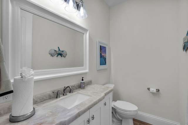 bathroom with hardwood / wood-style flooring, vanity, and toilet