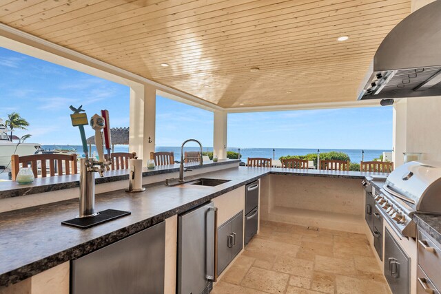 view of patio featuring area for grilling, sink, grilling area, and a water view