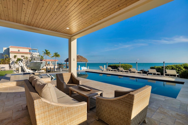 view of pool with a water view, an outdoor hangout area, and a patio area