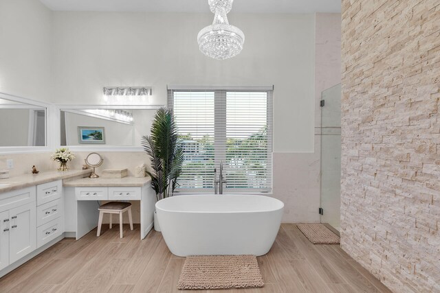 bathroom with vanity, shower with separate bathtub, a chandelier, and wood-type flooring