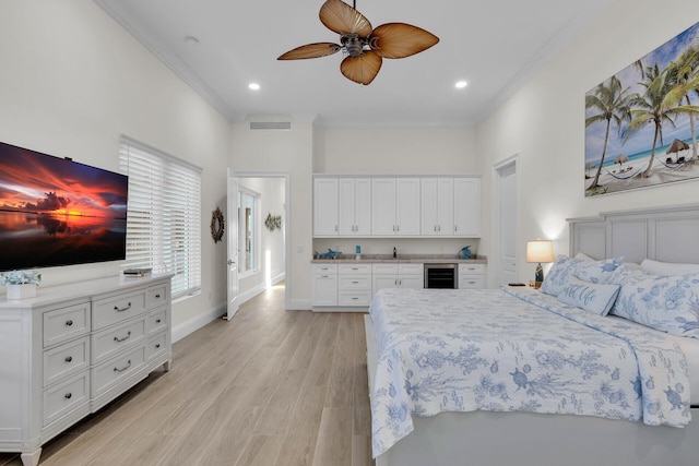 bedroom featuring wine cooler, sink, ornamental molding, and light hardwood / wood-style floors