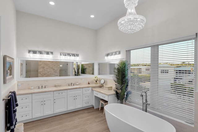 bathroom featuring vanity, a bathtub, an inviting chandelier, and hardwood / wood-style flooring