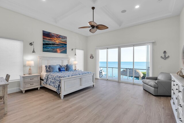 bedroom featuring coffered ceiling, access to exterior, light wood-type flooring, and a water view