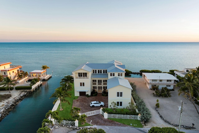 aerial view at dusk featuring a water view