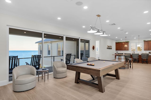 playroom featuring ornamental molding, a water view, pool table, and light hardwood / wood-style floors