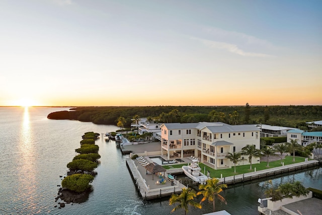 aerial view at dusk featuring a water view