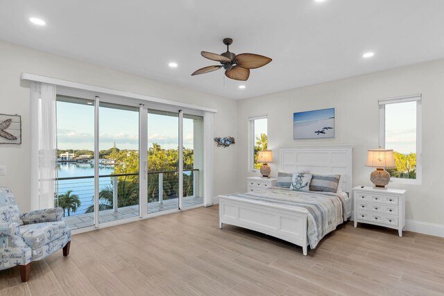 bedroom with a water view, ceiling fan, light hardwood / wood-style floors, and access to outside