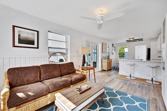 living room with light hardwood / wood-style flooring and ceiling fan