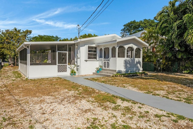 view of front facade featuring a front lawn and a sunroom