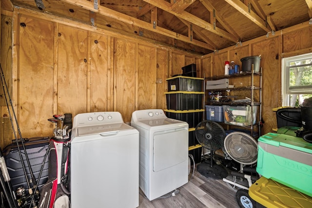 laundry area with separate washer and dryer, dark hardwood / wood-style floors, and wooden walls