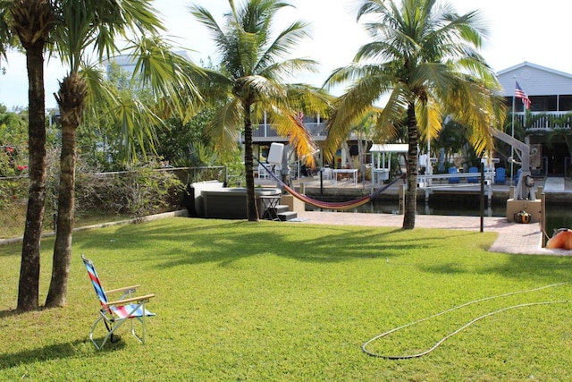 view of home's community with a dock and a lawn