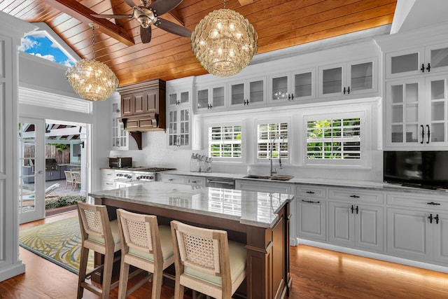 kitchen featuring a kitchen island, pendant lighting, white cabinetry, sink, and wood ceiling