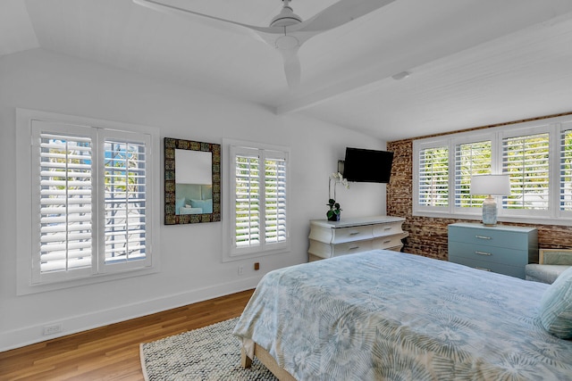 bedroom with multiple windows, vaulted ceiling with beams, ceiling fan, and light hardwood / wood-style flooring