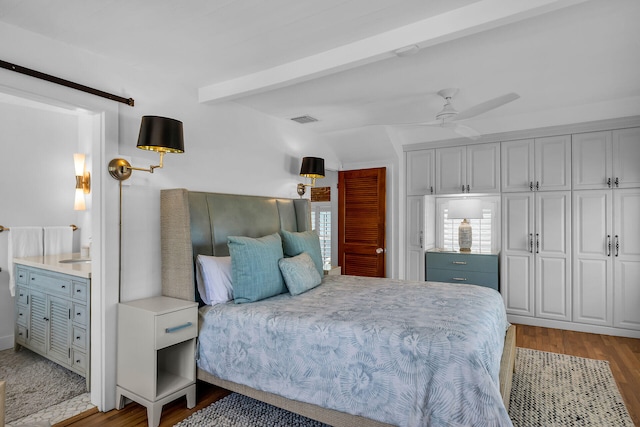 bedroom featuring sink, hardwood / wood-style flooring, lofted ceiling with beams, and ceiling fan