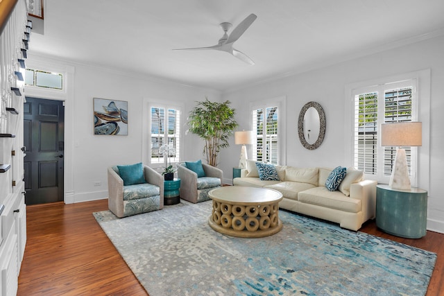 living room with dark hardwood / wood-style flooring, ornamental molding, and ceiling fan