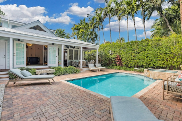 view of swimming pool featuring an outbuilding, a patio, and an in ground hot tub