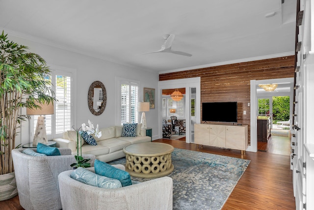 living room featuring wood-type flooring, ornamental molding, and ceiling fan