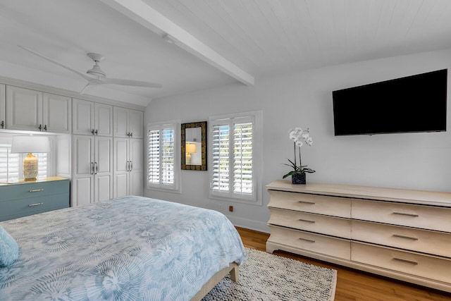 bedroom with ceiling fan, beam ceiling, and light hardwood / wood-style floors