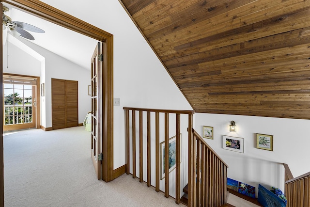 hall featuring light carpet, vaulted ceiling, and wooden ceiling