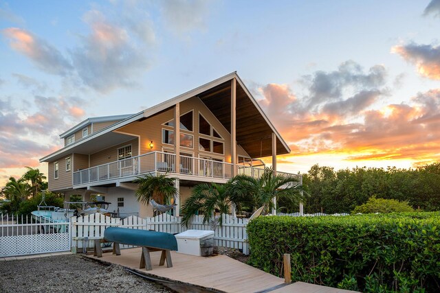 back house at dusk featuring a balcony