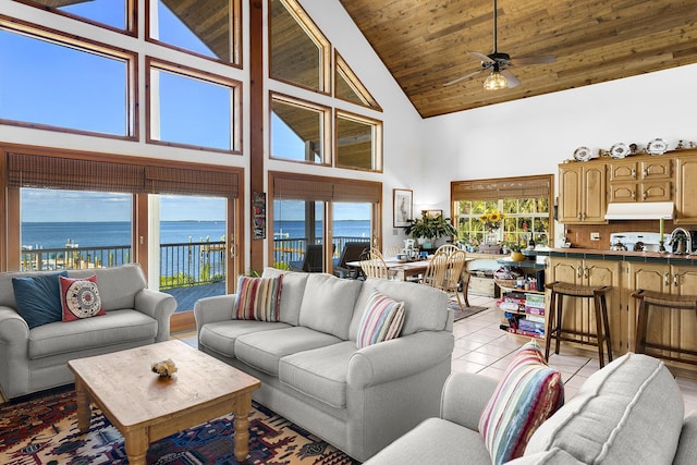 living room featuring a water view, high vaulted ceiling, wooden ceiling, light tile patterned floors, and ceiling fan