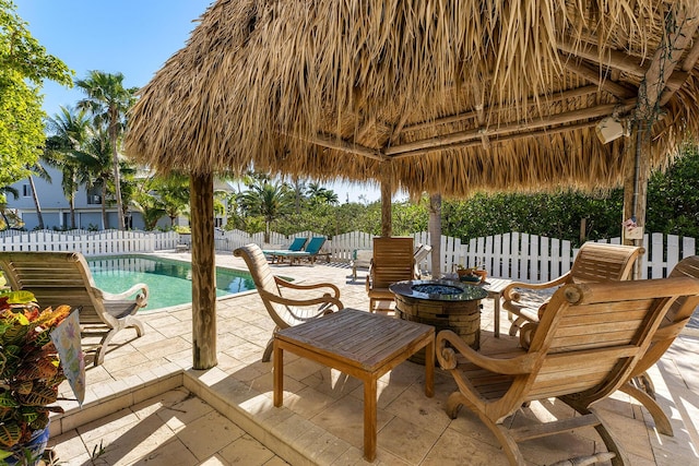 view of patio with a fenced in pool, a gazebo, and an outdoor fire pit