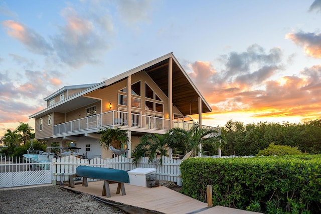 back house at dusk featuring a balcony