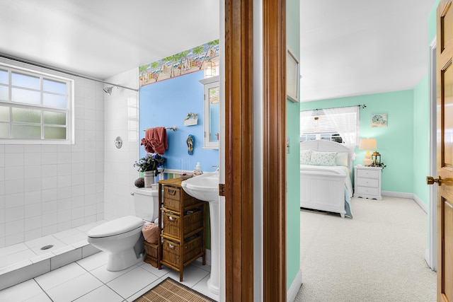 bathroom with a tile shower, sink, tile patterned floors, and toilet