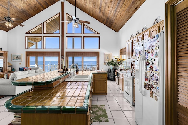 kitchen featuring sink, wood ceiling, white appliances, a center island, and tile countertops